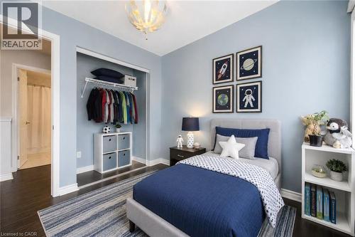 Bedroom featuring dark wood-finish flooring, light blue wall paint, and white baseboards - 1000 Asleton Boulevard Unit# 58, Milton, ON - Indoor Photo Showing Bedroom