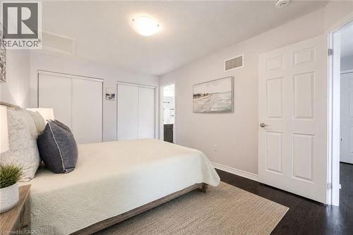 Bedroom featuring dark wood-finish flooring, light-colored walls, and a white ceiling with a flush-mount light fixture - 1000 Asleton Boulevard Unit# 58, Milton, ON - Indoor Photo Showing Bedroom