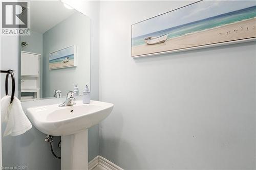Pedestal sink with chrome faucet, large wall mirror, and light blue wall finish - 1000 Asleton Boulevard Unit# 58, Milton, ON - Indoor Photo Showing Bathroom