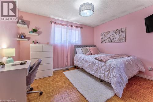 Bedroom featuring wood parquet flooring, a window with pink drapes and white sheer curtains, and a ceiling-mounted light fixture - 2560 Palisander Avenue, Mississauga, ON - Indoor Photo Showing Bedroom