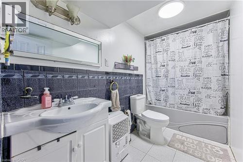 Bathroom featuring a white vanity with integrated sink, chrome faucet, and white paneled cabinetry - 2560 Palisander Avenue, Mississauga, ON - Indoor Photo Showing Bathroom