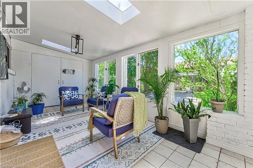 Bright sunroom featuring multiple skylights and expansive windows, white painted brick accents, and ceramic tile flooring - 2560 Palisander Avenue, Mississauga, ON - Indoor