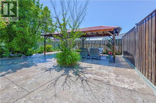 Expansive outdoor patio area featuring a wooden pergola with a red roof, bordered by a tall wooden privacy fence - 2560 Palisander Avenue, Mississauga, ON - Outdoor With Deck Patio Veranda
