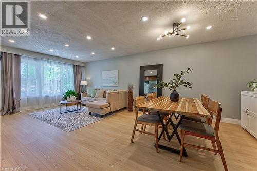 Open-concept living space with light wood-finish flooring, recessed lighting, and a contemporary chandelier - 2560 Palisander Avenue, Mississauga, ON - Indoor