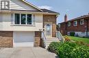 Brick and siding exterior featuring a white garage door, front entry with white storm door, and a concrete driveway - 56 Brookstream Court, Hamilton, ON  - Outdoor With Exterior 