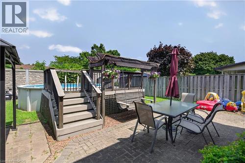 Expansive rear yard featuring an above-ground pool, multi-level wood deck, paver patio, and mature perimeter fencing - 56 Brookstream Court, Hamilton, ON - Outdoor With Deck Patio Veranda