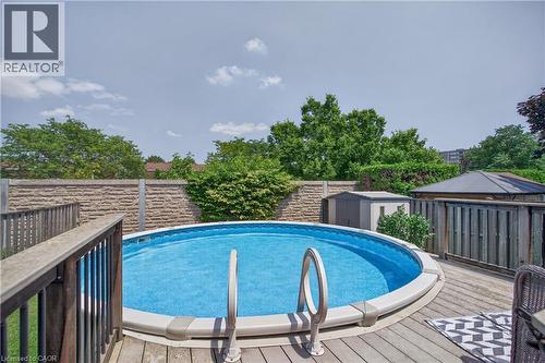 Expansive wooden deck surrounding a circular above-ground pool with integrated entry steps - 56 Brookstream Court, Hamilton, ON - Outdoor With Above Ground Pool With Deck Patio Veranda