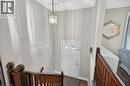 Entryway featuring a white paneled door with an arched window, a brass lantern-style pendant light, and a dark wood banister - 56 Brookstream Court, Hamilton, ON  - Indoor Photo Showing Other Room 