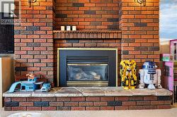 Brick fireplace featuring a stone hearth and a built-in firebox with a gold-tone trim - 