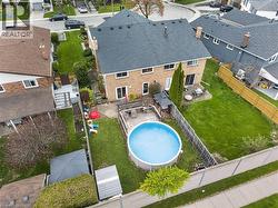 Expansive backyard featuring an above-ground pool, a spacious wooden deck with a gazebo, and a large lawn area - 