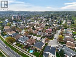 Expansive aerial perspective showcasing a residential neighborhood with varied single-family homes and mature trees - 