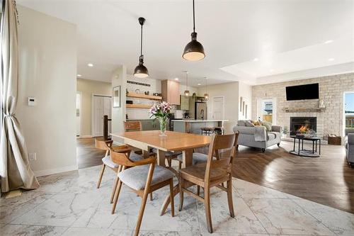 21 Glacier Bay, Steinbach, MB - Indoor Photo Showing Dining Room With Fireplace
