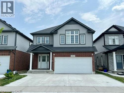 Two-story residence featuring a brick and siding facade, a two-car garage, and a covered front porch with white pillars - 300 Countrystone Crescent, Kitchener, ON - Outdoor With Facade