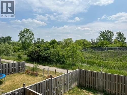 Private backyard with wood fencing bordering a natural green space and walking path - 300 Countrystone Crescent, Kitchener, ON - Outdoor