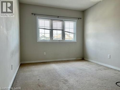 Neutral-toned room featuring a large window with white blinds and trim - 300 Countrystone Crescent, Kitchener, ON - Indoor Photo Showing Other Room