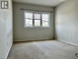 Neutral-toned room featuring a large window with white blinds and trim - 