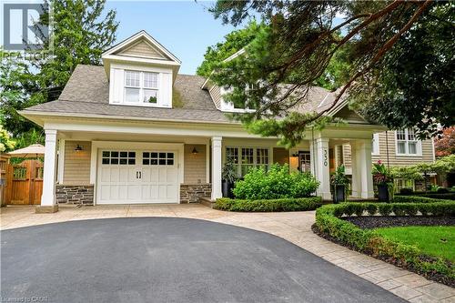 Craftsman-style exterior with dormer window, stone accents, shaker siding, and a white paneled garage door - 330 Camelot Court, Burlington, ON - Outdoor With Deck Patio Veranda With Facade