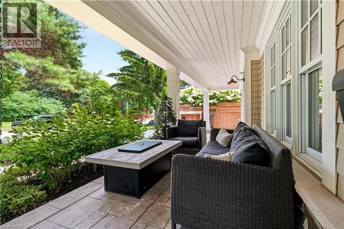 Covered porch featuring stamped concrete flooring, a shiplap ceiling, and an exterior sconce light - 330 Camelot Court, Burlington, ON - Outdoor With Deck Patio Veranda With Exterior