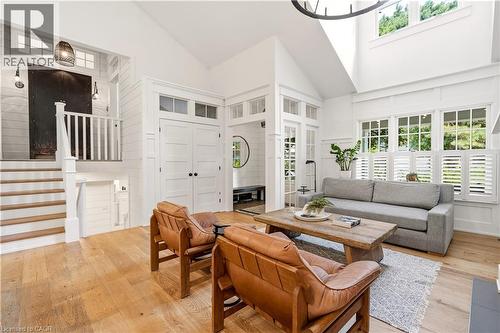 Vaulted ceilings with an exposed beam chandelier, a wood-finish staircase with white risers, and shiplap walls - 330 Camelot Court, Burlington, ON - Indoor Photo Showing Living Room