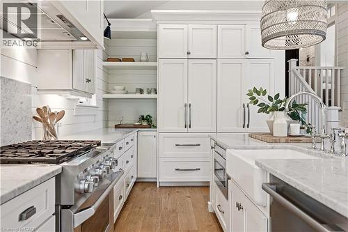 Gourmet kitchen with white shaker cabinetry, stainless steel professional-grade range, integrated refrigerator, white farmhouse sink, and light wood-finish flooring - 330 Camelot Court, Burlington, ON - Indoor Photo Showing Kitchen With Upgraded Kitchen