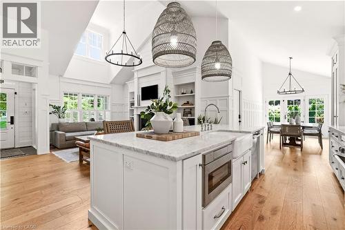 Kitchen island featuring a farmhouse sink, stainless steel microwave, and natural stone countertop - 330 Camelot Court, Burlington, ON - Indoor Photo Showing Kitchen