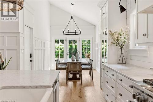 Spacious dining area featuring vaulted ceilings, wood-finish flooring, and French doors - 330 Camelot Court, Burlington, ON - Indoor Photo Showing Kitchen