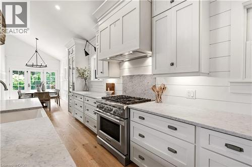 Kitchen featuring white shaker cabinetry, stainless steel range with matching hood, light-toned wood-finish flooring, and white countertops - 330 Camelot Court, Burlington, ON - Indoor Photo Showing Kitchen With Upgraded Kitchen