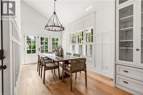 Dining area featuring natural wood-finish flooring, white paneled walls, and a vaulted ceiling - 330 Camelot Court, Burlington, ON - Indoor Photo Showing Dining Room