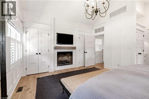 Room featuring a fireplace with a wood mantel, white wood-finish wall paneling, and light wood-finish flooring - 330 Camelot Court, Burlington, ON - Indoor With Fireplace