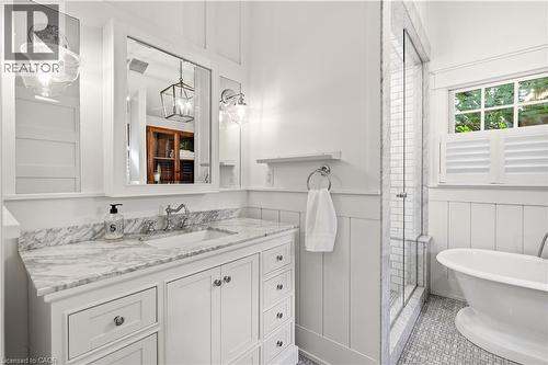White vanity with a stone countertop and integrated sink, chrome faucet, and mirrored medicine cabinet - 330 Camelot Court, Burlington, ON - Indoor Photo Showing Bathroom