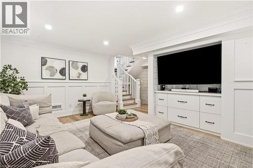 Entertainment area featuring a built-in media center with integrated shelving, recessed lighting, and wood-finish flooring - 330 Camelot Court, Burlington, ON - Indoor Photo Showing Living Room