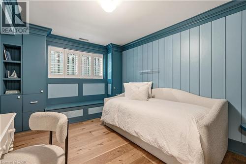 Custom built-in cabinetry and shelving frame a window with white plantation shutters - 330 Camelot Court, Burlington, ON - Indoor Photo Showing Bedroom