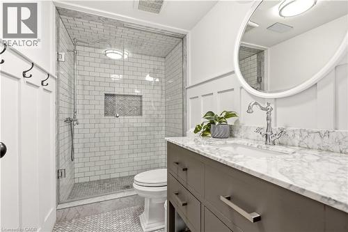 Bathroom featuring a glass-enclosed shower with subway tile, a recessed niche, and a contrasting herringbone floor - 330 Camelot Court, Burlington, ON - Indoor Photo Showing Bathroom
