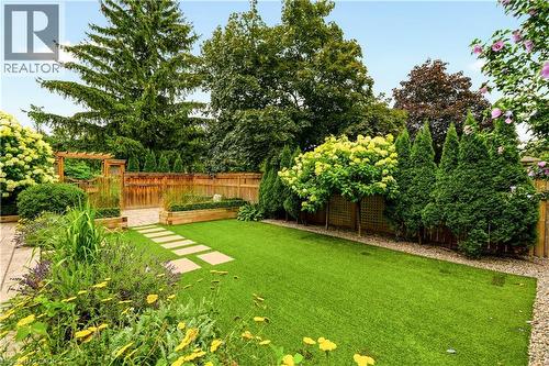 Landscaped backyard featuring lush green lawn and perimeter plantings - 330 Camelot Court, Burlington, ON - Outdoor