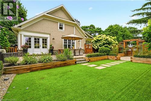 Manicured lawn with stepping stones, bordered by wood-retained garden beds - 330 Camelot Court, Burlington, ON - Outdoor