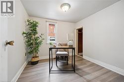 Room with light gray walls, wood-finish flooring, and a white trim package - 