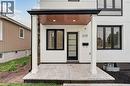 Modern white stucco exterior featuring a covered entryway with a wood-finish ceiling - 325 Queensdale Avenue E, Hamilton, ON 