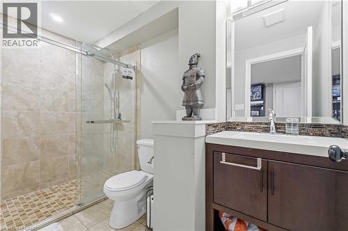Bathroom featuring a glass-enclosed shower with tile surround, a dark wood-finish vanity with an integrated sink, a mosaic tile backsplash, and a framed mirror - 212 Chartwell Circle, Hamilton, ON - Indoor Photo Showing Bathroom