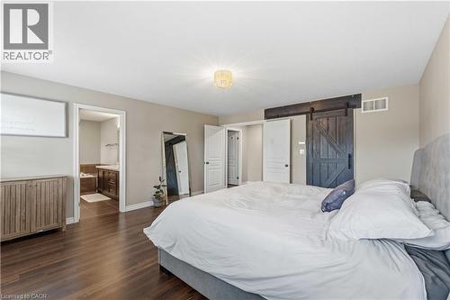 Spacious room featuring wood-finish flooring, a contemporary ceiling light fixture, and neutral wall tones - 212 Chartwell Circle, Hamilton, ON - Indoor Photo Showing Bedroom