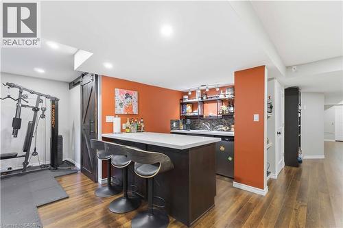 Entertainment area featuring a wet bar with a light countertop, dark wood-finish cabinetry, and a dark tile backsplash - 212 Chartwell Circle, Hamilton, ON - Indoor