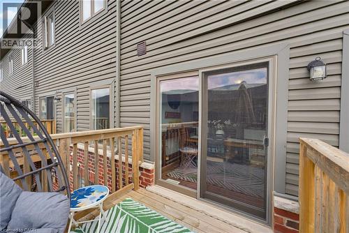 Outdoor wood deck featuring a sliding glass door with screen, wood railing, and brick base - 324 Equestrian Way Unit# 49, Cambridge, ON - Outdoor With Deck Patio Veranda