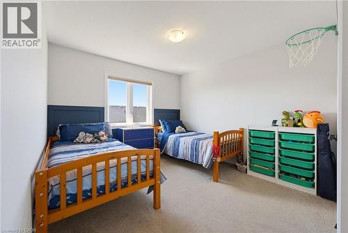 Room featuring light neutral wall paint, a window with white trim, and a blue accent wall paneling - 324 Equestrian Way Unit# 49, Cambridge, ON - Indoor Photo Showing Bedroom