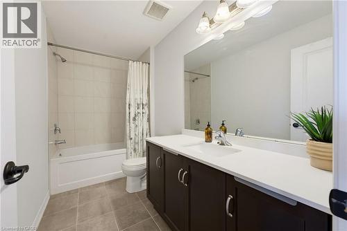 Bathroom featuring a spacious single-basin vanity with dark wood-finish cabinetry and a light-toned countertop - 324 Equestrian Way Unit# 49, Cambridge, ON - Indoor Photo Showing Bathroom