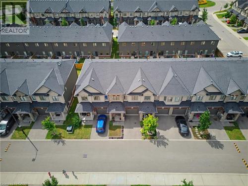 Modern townhome community featuring uniform dark gray roofs and light-toned siding - 324 Equestrian Way Unit# 49, Cambridge, ON - Outdoor With View
