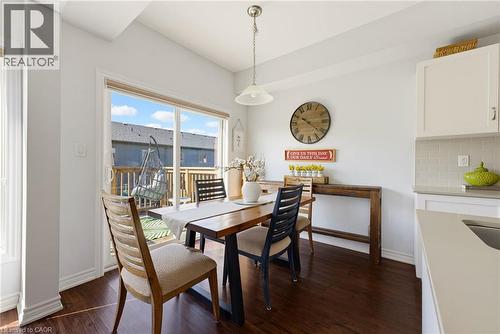 Dining area featuring dark wood-finish flooring, white baseboards, and a sliding glass door to an outdoor deck - 324 Equestrian Way Unit# 49, Cambridge, ON - Indoor Photo Showing Dining Room
