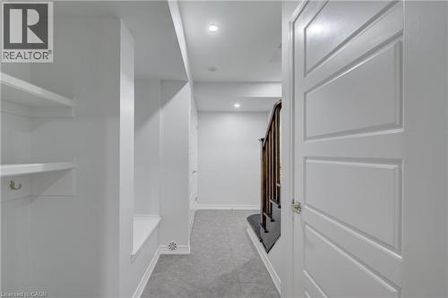 Hallway with recessed lighting, built-in shelving, panel doors, and a wood-finish staircase - 911 Apple Hill Lane, Kitchener, ON - Indoor Photo Showing Other Room