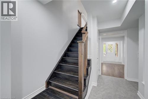 Wood-finish staircase with natural wood handrail and balusters - 911 Apple Hill Lane, Kitchener, ON - Indoor Photo Showing Other Room