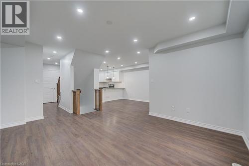 Expansive open-concept living space with wood-finish flooring and recessed lighting - 911 Apple Hill Lane, Kitchener, ON - Indoor Photo Showing Other Room