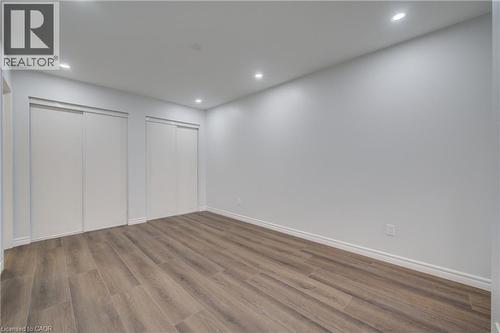Spacious room featuring wood-finish flooring, recessed lighting, and white baseboards - 911 Apple Hill Lane, Kitchener, ON - Indoor Photo Showing Other Room