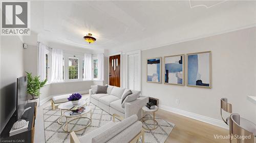 Living area featuring light wood-finish flooring and a distinctive bay window with multiple panes - 59 Longwood Road N, Hamilton, ON - Indoor